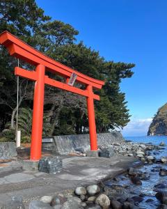 户田Calmbase Nishi Izu - Vacation STAY 30929v的靠近水面的海滩上的一个橙色的Torii门