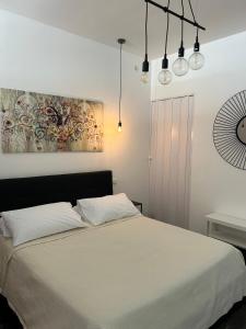 锡拉库扎Ortigia Loft Via Malta, 22的一间卧室配有白色床单和灯。