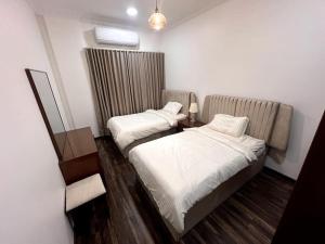 阿可贺巴Ban Luxury Apartments的小型客房的两张床,配有镜子