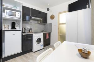 泰昂维Le petit MIAMI的厨房配有洗衣机和桌椅