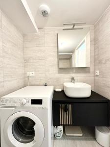 拉尔莫普拉格Spacieux T4 neuf de standing - Plein bourg的一间带洗衣机和水槽的浴室