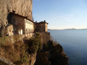 Due CossaniAntico Borgo Del Lago Maggiore的悬崖边的水边的建筑物