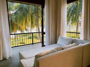 达瓦拉维Tsuru Villa的带沙发和大窗户的客厅