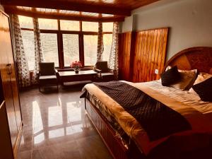 马拉里Hotel Kanchan Classic Manali的一间卧室设有一张大床和一个大窗户
