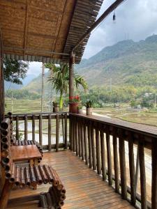 枚州县Mai Chau La Vida Homestay的木门廊设有长凳,享有山景