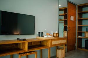 坎古Ecozy Dijiwa Canggu的客厅配有木桌上的电视