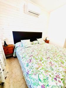 阿雷纳斯德圣佩德罗Hostal La Taberna的一间卧室配有一张带花卉棉被的大床
