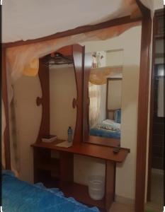 VoiTHE DESERT ROSE HOTEL VOI的一间卧室配有一张带镜子的木桌