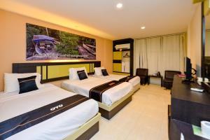 丹戎槟榔OYO 2487 Sampurna Jaya Hotel的酒店客房设有两张床和电视。