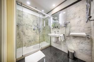 布拉格Esplanade Hotel Prague的一间带玻璃淋浴和水槽的浴室