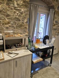 圣雷莫Primafila Premium Guest House的厨房配有桌子和石墙