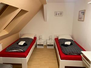 普劳恩FeWo WIEKO Plauen Leibnizstr. H3, DG rechts的红色和白色的客房内的两张床