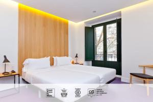 马德里SLEEP'N Atocha - B Corp Certified的卧室设有一张白色大床和一扇窗户。