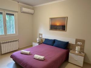 卡尔佩Villa Maja的一间卧室配有一张紫色床和两个枕头