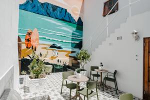 开普敦Cape Finest - 31 on Jarvis的一间设有桌椅的餐厅,墙上挂着壁画
