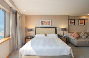迪拜迪拜广场凯悦公寓式酒店的一间卧室配有一张大床和一张沙发