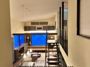 二世古新雪谷伊苏米克亚酒店的楼梯通往带大窗户的客房