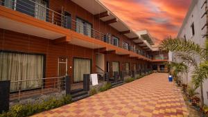 曼达莫尼Sea Queen Beach Resort On Beach的建筑的走廊,背景是日落