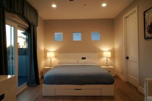圣地亚哥Modern comfort, prime location, 360 views, 4 BR entire house的一间卧室配有一张大床和两盏灯
