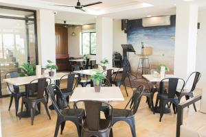 长滩岛Bloom Boracay的餐厅设有桌椅,墙上挂有绘画作品