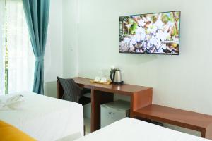长滩岛Bloom Boracay的酒店客房设有一张桌子和一台墙上的电视。