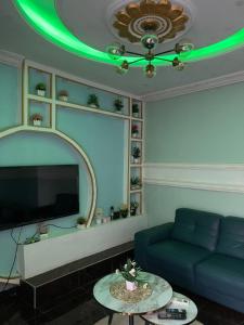 林贝Primier Mansion Guest Home的客厅设有蓝色的沙发和绿色的天花板。