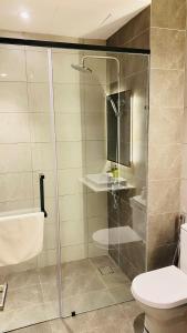 吉隆坡Axon suites by GALAXY HOUSE的浴室设有玻璃淋浴间和卫生间