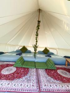 琅勃拉邦Glamping Laos的帐篷内的一张床铺,上面插着花