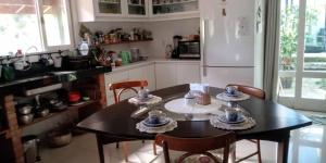 巴拉奈里奥-坎布里乌Quarto na Praia de Taquaras的厨房配有桌椅和冰箱。