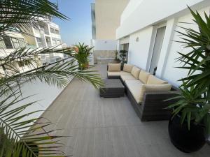 卡萨布兰卡Central, terrasse, confortable - Bleue résidence的一座配有沙发的庭院,一座建筑里种植了植物