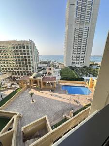 迪拜Bollywood Beach Hostel的享有带游泳池和建筑的建筑景致