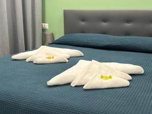 丽都迪奥斯蒂亚Casa Marel的两张床,配有白色毛巾和黄色弓