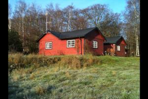 锡姆里斯港Sagolikt läge med havsutsikt i Rörum på Österlen的田间中的一个红色房子