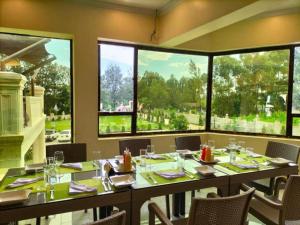 MuhoroniKoru Country Club的一间设有桌子和窗户的大型用餐室