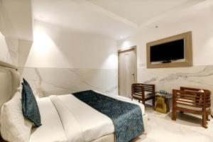 新德里Hotel Delhi 37 by Star Group NEAR DELHI AIRPORT的一间卧室配有一张床,墙上配有电视