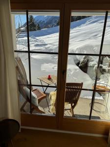 达沃斯Chalet Studio - Top Ausstattung - beste Lage Davos的透过带桌子的房间窗户可欣赏到风景