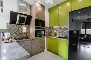 华沙ShortStayPoland Aleja Rzeczypospolitej (B157)的厨房配有绿色橱柜和台面