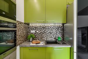 华沙ShortStayPoland Aleja Rzeczypospolitej (B157)的厨房配有绿色橱柜和水槽