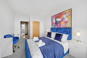 KentRetreat: Seaside Bliss In Ramsgate的一间卧室配有一张带蓝色毯子的大床