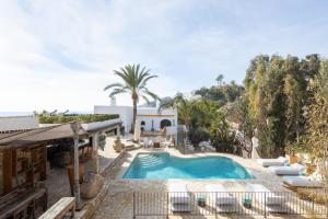 比利亚霍约萨Buccara Villa Mistral的庭院中的游泳池,带椅子和房子