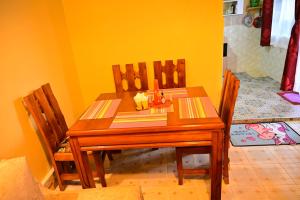 NarokTHE PINGS BNB的餐桌、三把椅子和黄色墙