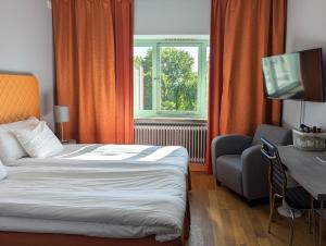 锡格蒂纳克里斯蒂娜酒店的酒店客房配有一张床、一张书桌和一台电视。