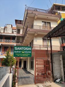 博卡拉santoshi guest house的一座标有旅馆标志的建筑