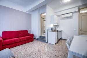 佛罗伦萨YID Agnolo three bedroom apartment in Florence的一间带红色沙发的客厅和一间厨房