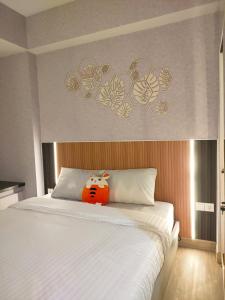 WarungmanggaNewly renovated apartement @ collins boulevard的床上坐着一只塞满食物的动物