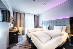 科隆Premier Inn Köln City Mediapark的酒店客房配有两张床和一张书桌