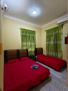 停泊岛Perhentian Idaman的一间卧室配有两张红色床单