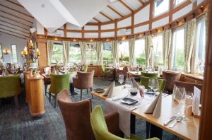 宁布雷希特德里奇维勒霍夫酒店的餐厅设有桌椅和窗户。