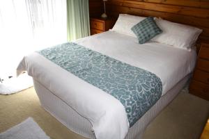 彭特派因Lavendula Garden Cottage的一间卧室配有一张带蓝白色毯子的床