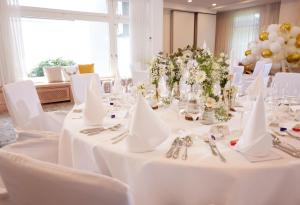 宁布雷希特德里奇维勒霍夫酒店的用餐室配有白色的桌子和白色的椅子